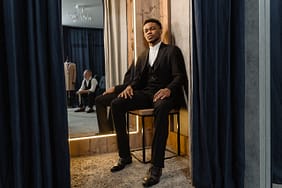 Man in Black Suit Sitting on Brown Wooden Chair